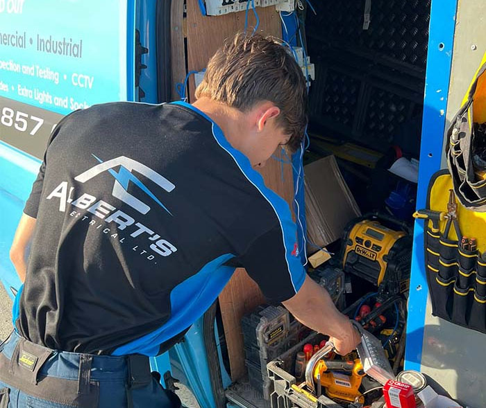 Albert's electrical team member cole grabbing equipment from van.